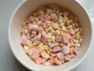 椒盐红薯玉米粒,然后翻拌均匀，让所有玉米粒和红薯粒都沾上粉类混合物；