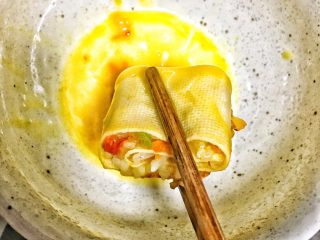 香脆黄金豆皮卷,鸡蛋取蛋黄液放入碗里，将做好的卷子在蛋黄液里沾一下