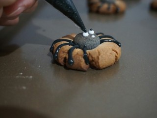 蜘蛛饼干,饼干晾凉，用糖霜画出蜘蛛的表情。