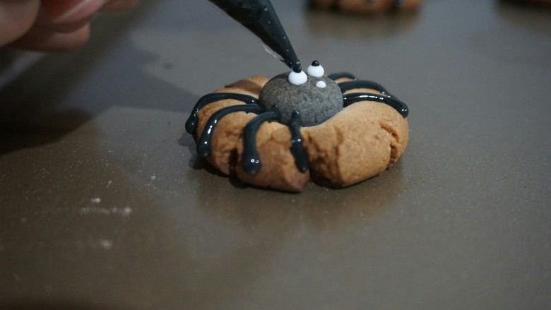 蜘蛛饼干,饼干晾凉，用糖霜画出蜘蛛的表情。