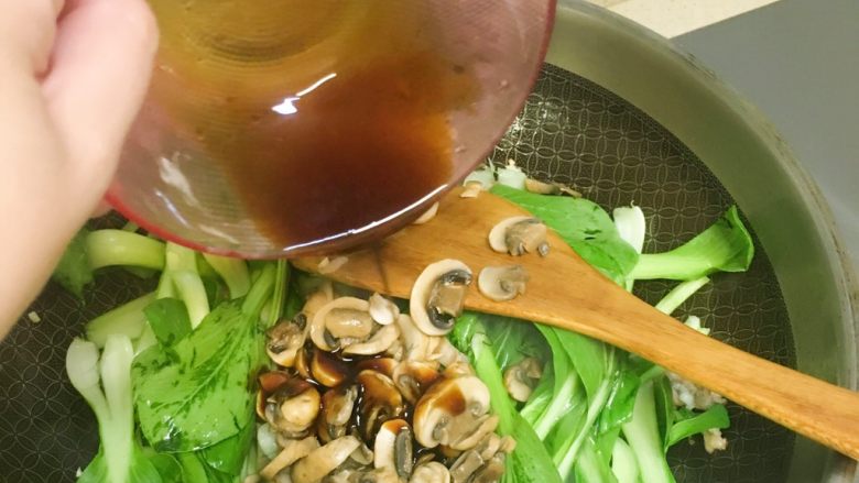 洋菇溜油菜,把调料汁淋进去，继续翻炒。