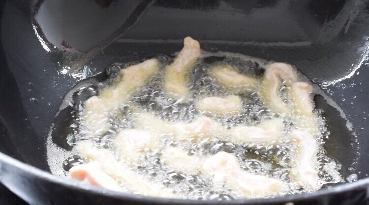 鸡肉版糖醋里脊,锅中的油烧至六成热放入鸡肉条，小火炸至淡黄色