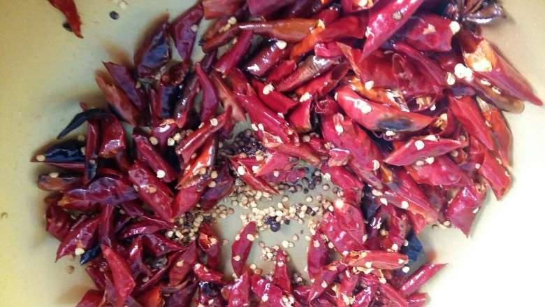 辣子鸡,锅底留少许油，倒入花椒麻椒和辣椒，小火翻炒出香味。