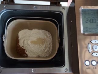 香蕉可可花边包,在面粉顶端加入酵母，将面包桶放入到东菱1352AE-3C面包机里