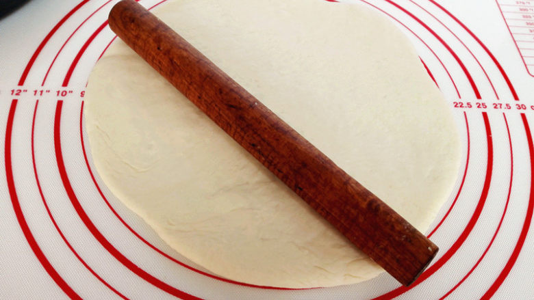 海陆至尊披萨,把面团发在揉面垫上，如果沾可以适量撒些干面粉，擀成比模具略小的圆盘，