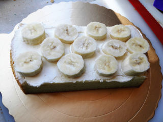 小汽车蛋糕,主体蛋糕切成两片，中间抹淡奶油，香蕉切片夹在中间，