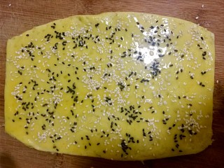 红薯饼干棒,把面团擀成0.5厘米厚的薄片，抹上蛋液，均匀的撒上黑白芝麻
