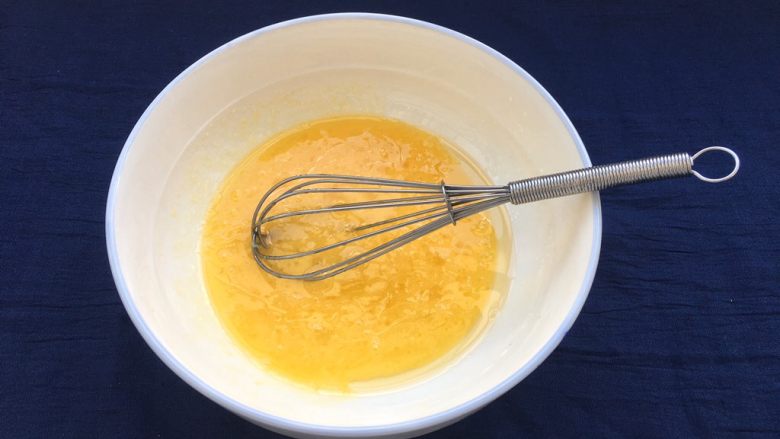 椰蓉酥,鸡蛋磕入碗中，与玉米油、白糖抽打均匀，打好是这个状态的，稠稠的。
