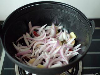 【再添一碗饭】の番茄牛腩锅,放入洋葱，快速翻炒均匀，直到洋葱慢慢变软的状态