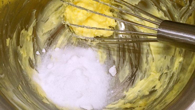 一口莲蓉酥,把15克砂糖加进黄油中，继续搅拌均匀。