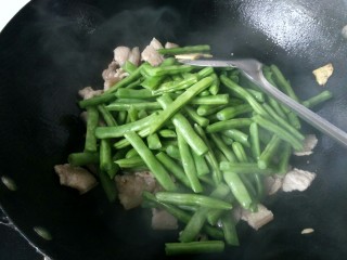 绿色美食+干锅四季豆（微辣）,倒入四季豆，放适量的盐并翻炒。