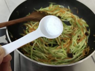 绿色美食～素炒西葫芦丝,加入盐翻炒均匀，这道菜不宜加酱油，否则颜色不好看哟