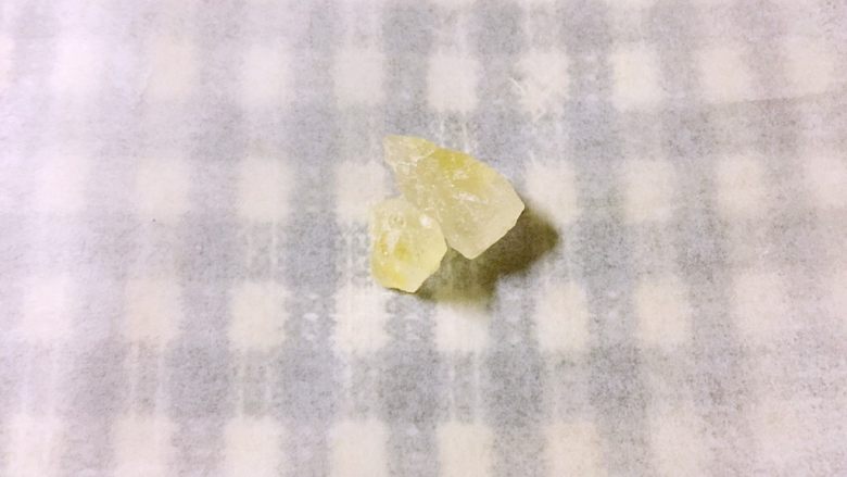碧螺金桂冰糖饮,撕一张干净的长方形纸，将5克黄冰糖放在中间