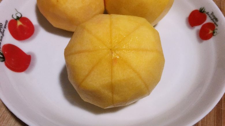 黄桃罐头,从中间花刀对半切开，用小刀或勺子把从后面将黄桃瓣剥下。