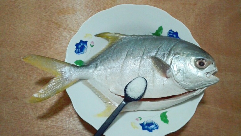 红妆素裹金昌鱼,放进盘中，一小勺盐均匀撒在鱼表面和肚子里面，轻轻用手搽一搽，使盐快速渗透到鱼肉里面，腌十五分钟，不要腌时间长，不然鱼肉不嫩