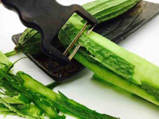 #绿色美食# 下饭神菜  面筋丝瓜煲,用刮皮刀将主要食材丝瓜的皮刮去。