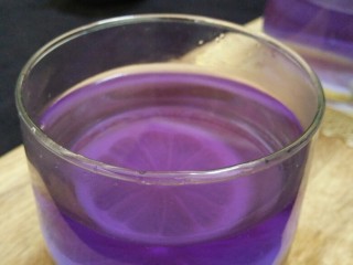 冬喝暖饮夏吃冰---蝶豆花柠檬饮,在刚冲好的蓝色蝶豆花饮中，加入一片蜂蜜柠檬，立刻就变成了漂亮的紫色。