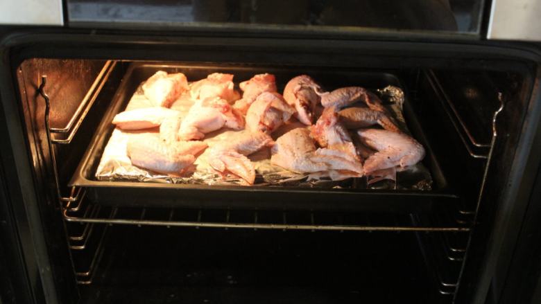 可乐辣味鸡翅,烤箱预热后，以200℃烤35-40分直到表面变焦黄。中间可以翻面一次。