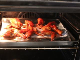 可乐辣味鸡翅,再将鸡翅再放在有架铁架的烤盘上，放回烤箱，以180℃再烤7分钟。
