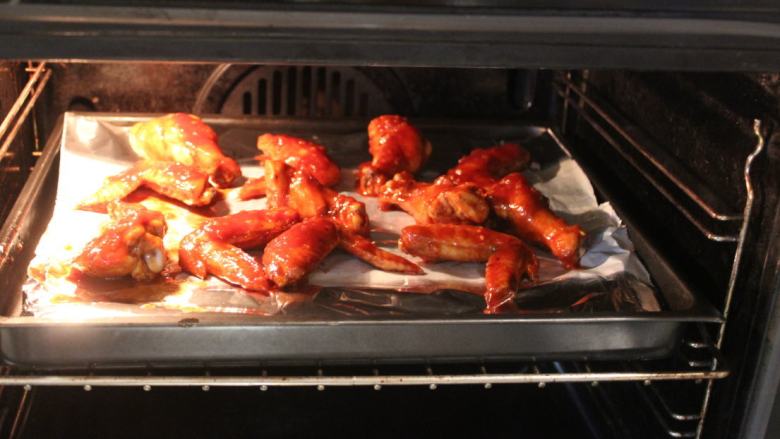 可乐辣味鸡翅,再将鸡翅再放在有架铁架的烤盘上，放回烤箱，以180℃再烤7分钟。