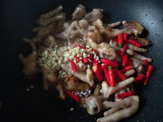 香辣卤鸡爪,放入小米椒和姜末，翻炒均匀。