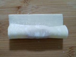 馄饨皮的花样吃法,用馄饨皮把烤肠包住卷起，卷到边缘处用筷子沾少量清水抹在馄饨皮上。