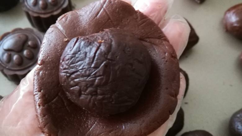 巧克力月饼（超详细）,巧克力皮在手上按压成薄片，包入一个巧克力馅，滚圆。