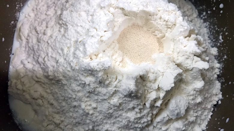 十足的软妹子——中种酸奶吐司,在粉堆的一角放入盐，粉堆中间挖个小坑放入酵母粉再盖起来