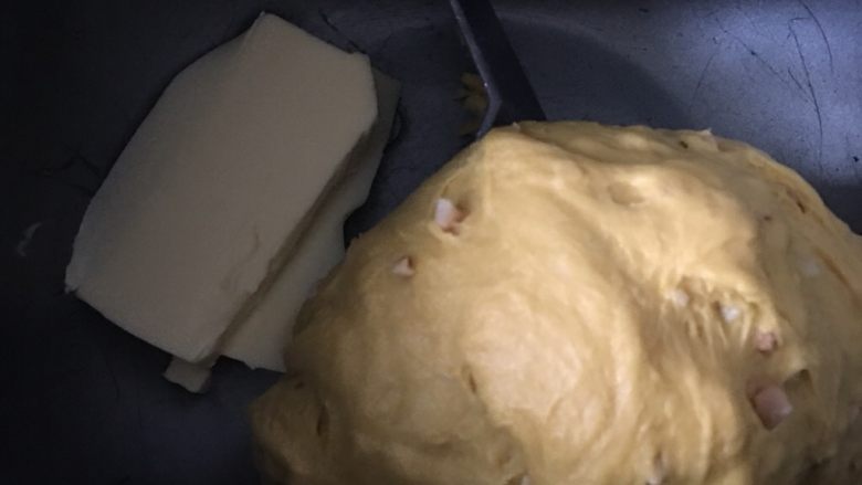 南瓜花生乳酪面包,待花生和面团揉至均匀光滑后加入软化的黄油，继续揉面