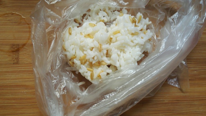 剩米饭紫薯泥卷,把剩米饭倒入一个保鲜袋中。