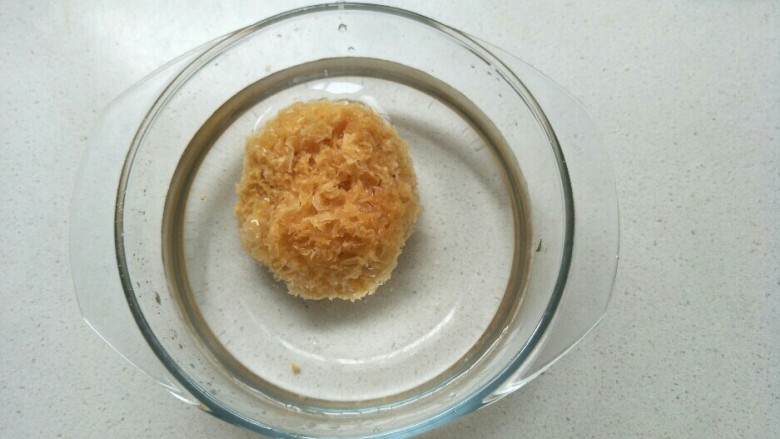 苹果银耳蜜枣羹,把银耳放在玻璃碗中加入水浸泡。