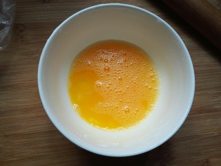 剩米饭紫薯泥卷,用筷子把鸡蛋打散。