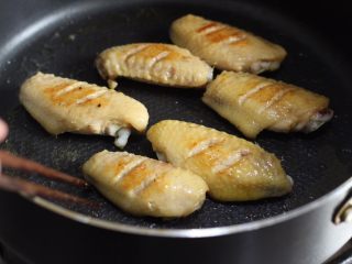 咖喱鸡翅,锅中加油，入鸡翅煎至两面金黄，捞出备用。