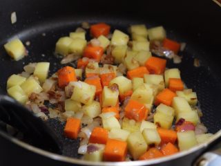 咖喱鸡翅,加入土豆丁和胡萝卜丁翻炒片刻。
