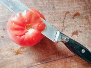 孜然土豆片,下面做一朵蕃茄玫瑰🌹，做装饰用：如图，从蕃茄的蒂部开始，转圈削下蕃茄皮，不要削断。
