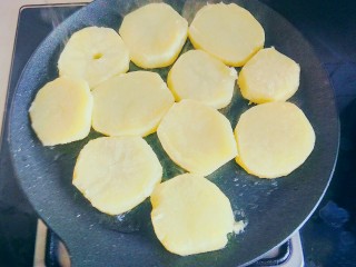 孜然土豆片,放入煮熟的土豆片，用中小火，将土豆的两面煎黄后倒出待用。