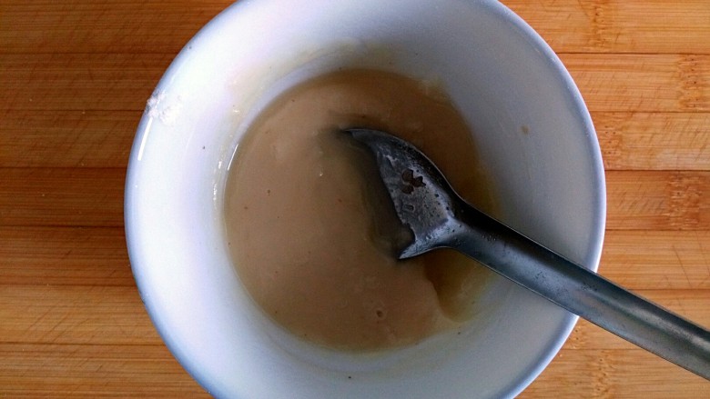 奶香油酥核桃饼,取一空碗倒入4勺面粉，倒入热好的油，搅拌均匀，晾凉待用