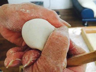 北方特色饺子 茴香馅水饺（附和馅小技巧）,先将饺子皮对折，中间捏紧，然后用双手的拇指和食指将饺子皮的边向中间轻轻挤压。