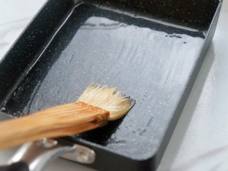 芝士肉松玉子烧,取玉子烧专用煎锅，锅底薄薄地刷上一层食用油，小火加热。