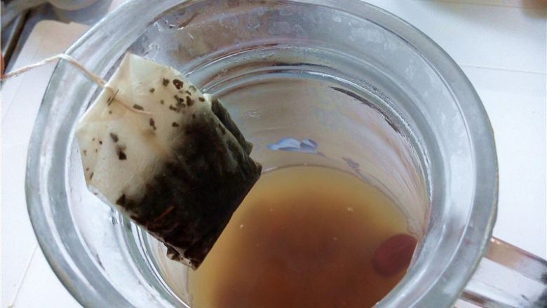 秋冬季养胃暖身最佳饮品--姜枣奶茶,将壶中浸泡的茶包取出来，摇动几下使得茶汤均匀就可以了；