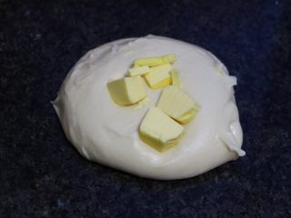 菠萝包,手工摔打揉面至面团光滑。当然也可用面包机厨师机机揉。后油法，加入从冰箱取出切成小块的黄油裹住，揉搓至黄油完全吸收。