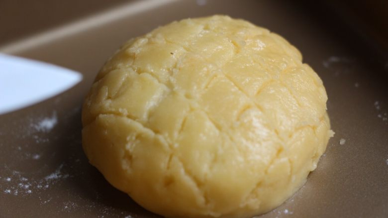 菠萝包,用刀轻轻地在酥皮上划出格子菠萝纹。也可以用模具印花纹比较整齐。此时烤箱预热190度。