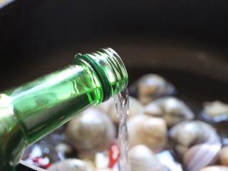 酒蒸文蛤,倒入清酒或米酒加盖焖煮片刻。