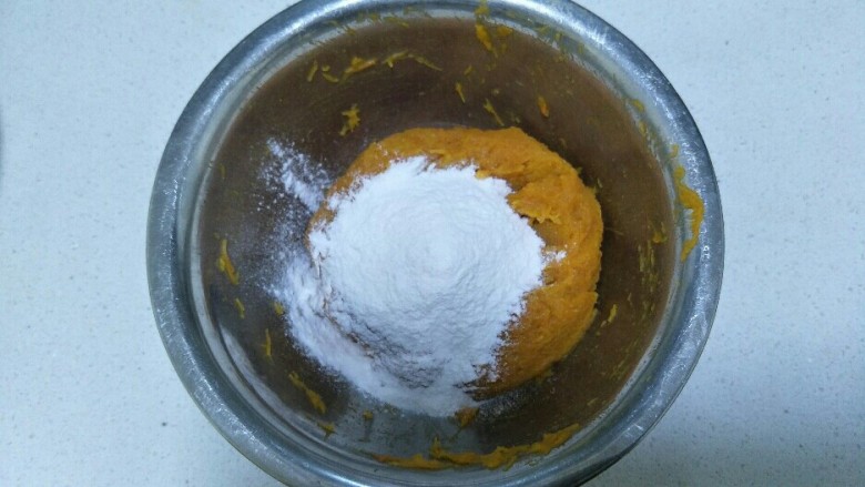 软糯南瓜饼,南瓜压好后，加入糯米粉和适量的糖，慢慢的试，直到把南瓜泥和糯米粉揉成团。