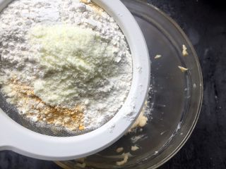 万圣节-南瓜鬼脸饼干,然后将面粉、南瓜粉、奶粉一起筛入黄油鸡蛋糊中。