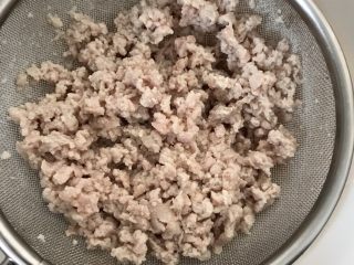 韭菜肉松粥,肉糜放碗中用开水焯烫后沥干。