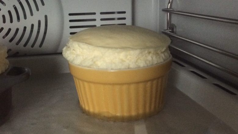 舒芙蕾乳酪蛋糕,膨胀到最高后开始回落便烤好了，继续放烤箱焖30分钟。