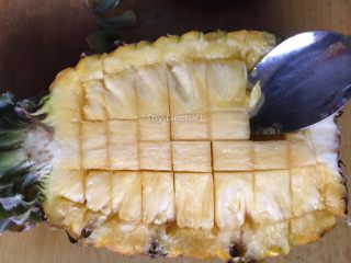 咖喱菠萝炒饭,首先将菠萝切半，在菠萝肉上用刀划格子形，不要划破菠萝皮