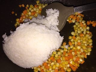 咖喱菠萝炒饭,接着加入白米饭，用铲背压扁后炒开均匀