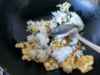 五彩炒饭,把剩米饭倒入锅中，将米饭炒散。